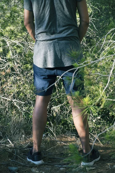 Молодой человек писает в лесу — стоковое фото