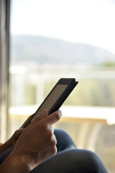 Homme lisant dans une tablette ou un lecteur électronique — Photo