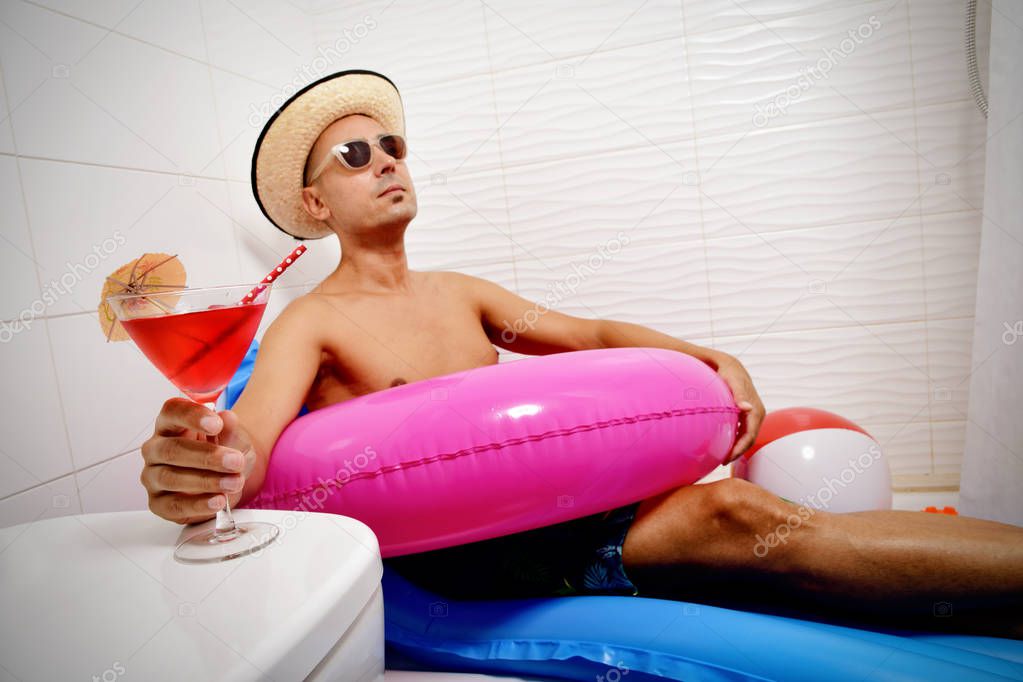 man with a swim ring relaxing in the bathroom
