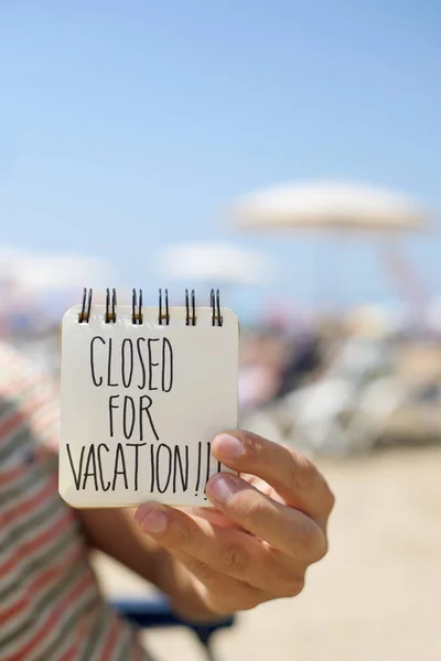Mann mit Zettel, auf dem der Text für den Urlaub geschlossen ist — Stockfoto