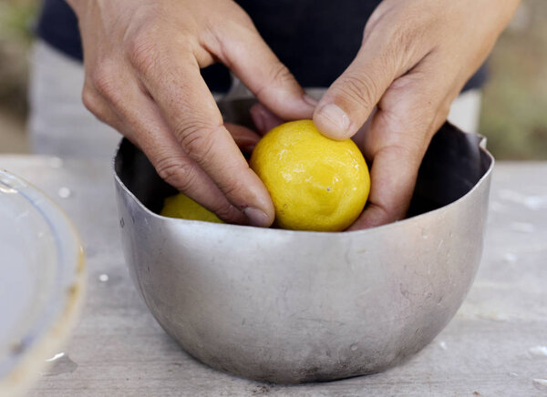 молодой человек чистит лимоны
