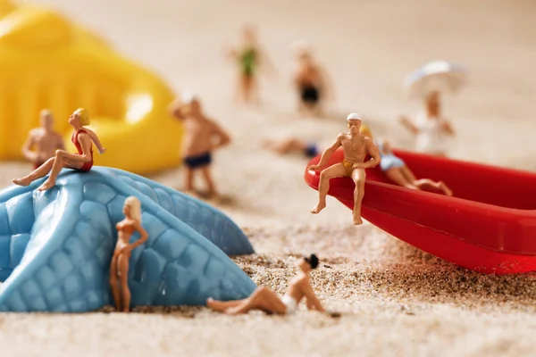 Pessoas em miniatura em maiô na praia — Fotografia de Stock