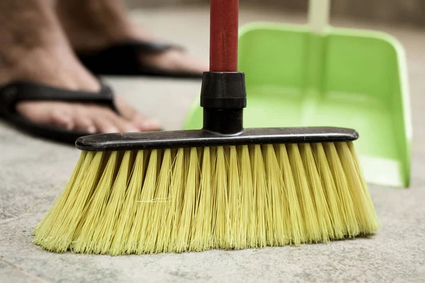 Jovem varrendo o chão com uma vassoura — Fotografia de Stock