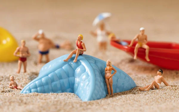 Pessoas em miniatura em maiô na praia — Fotografia de Stock