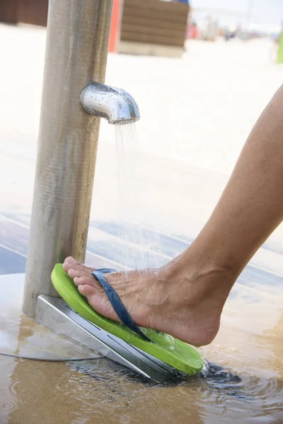 Homme se lavant les pieds sur la plage — Photo