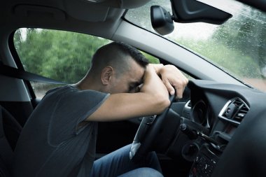 genç adam bir araba direksiyon üzerinde dinlenme