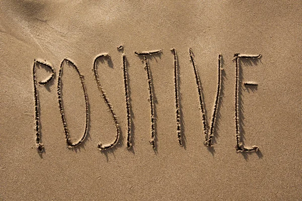 Positiver Text im Sand eines Strandes geschrieben — Stockfoto