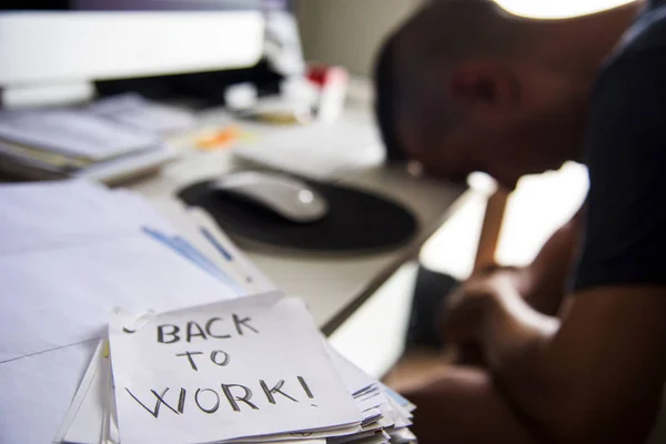 Man på kontoret och text tillbaka att arbeta i en anteckning — Stockfoto