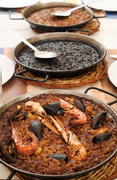 Spanska skaldjur paella, svart paella och fideua — Stockfoto