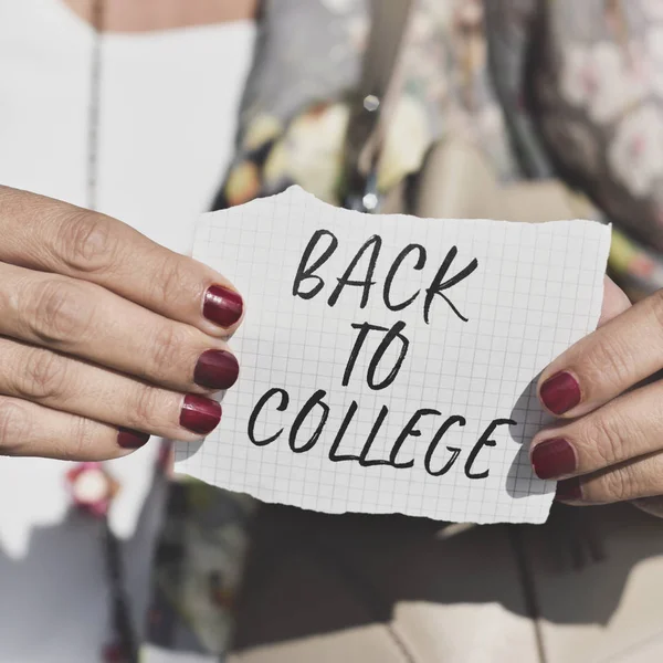 Studente con una nota con il testo torna al college — Foto Stock