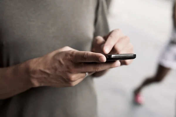 Ung man med en smartphone i gatan — Stockfoto