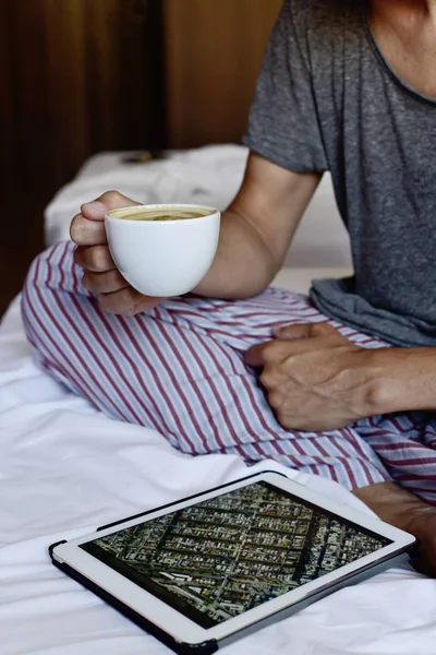 Junger Mann mit Kaffee und Tablette — Stockfoto