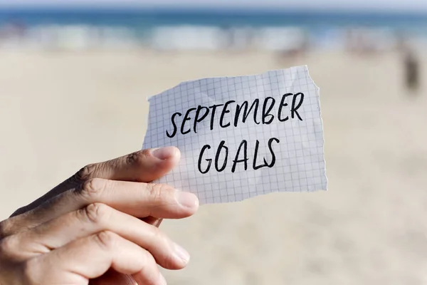 Man with a note with the text september goals — Stock Photo, Image