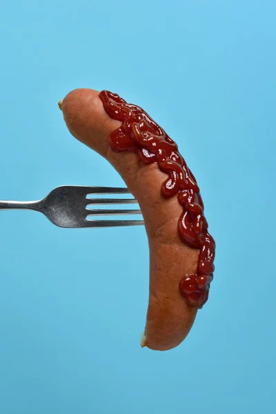 Cachorro-quente com ketchup em um garfo — Fotografia de Stock