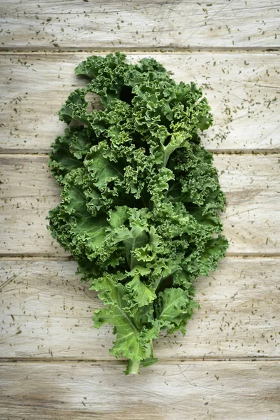 Grünkohlblatt auf einem rustikalen Holztisch — Stockfoto