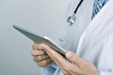 bir tablet bilgisayar kullanan doktor adam