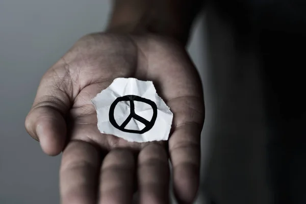 Homem com um símbolo de paz num pedaço de papel — Fotografia de Stock