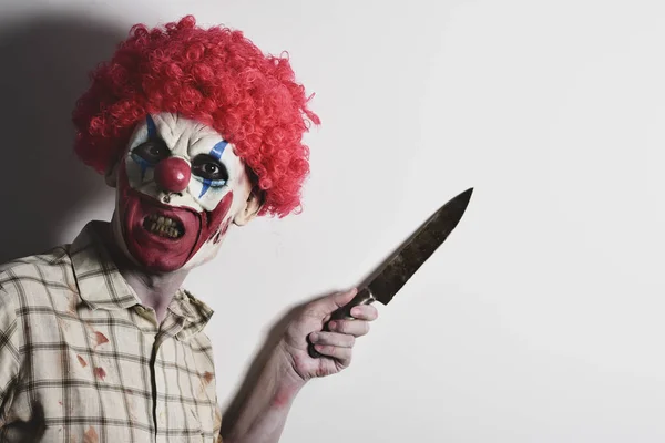 Aterrador payaso malvado con un cuchillo grande — Foto de Stock