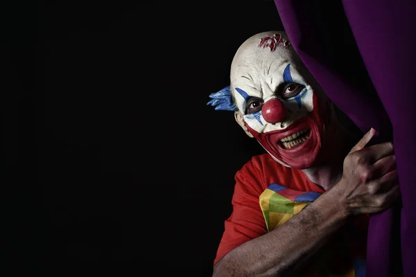 Aterrador payaso malvado asomándose desde una cortina de escenario —  Fotos de Stock