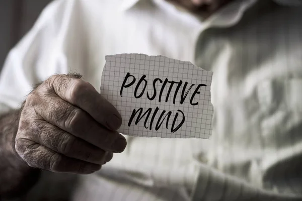 Old man with a note with the text positive mind — Stock Photo, Image