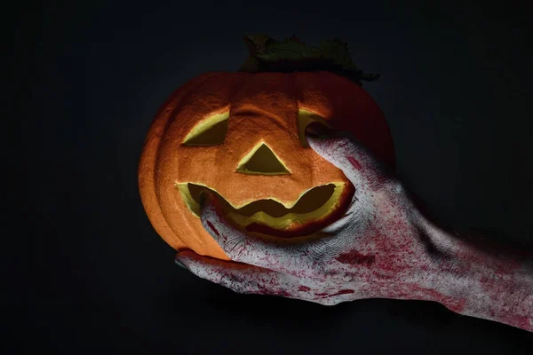 Zombie mit einem geschnitzten Kürbis — Stockfoto
