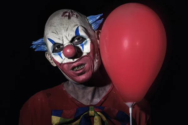 Aterrador payaso malvado con un globo rojo —  Fotos de Stock