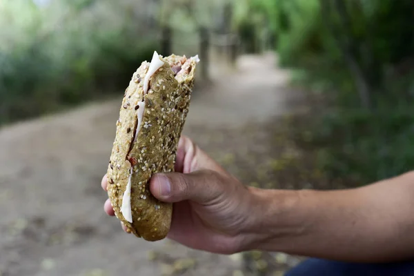 Jovem comendo um sanduíche ao ar livre — Fotografia de Stock