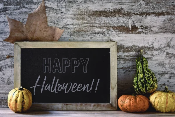 Schoolbord met tekst happy halloween en pompoenen — Stockfoto