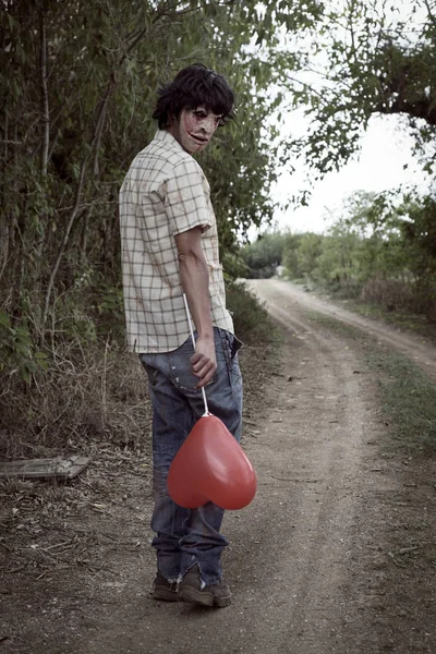 Aterrador hombre desfigurado con un globo — Foto de Stock