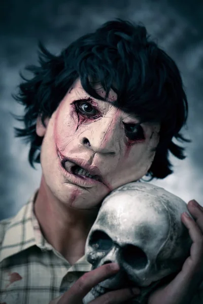 Aterrador hombre desfigurado con un cráneo — Foto de Stock