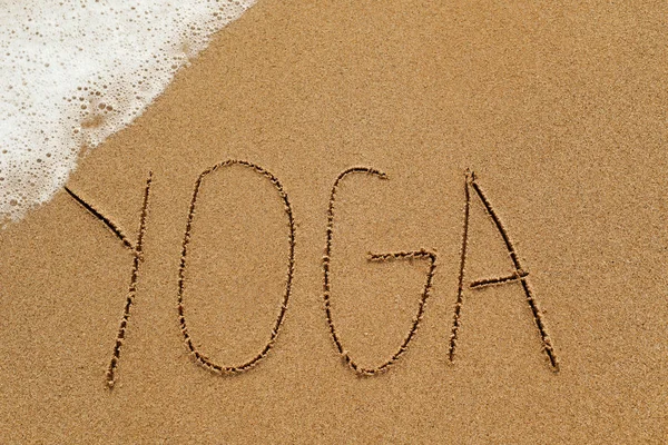 Word yoga in het zand — Stockfoto