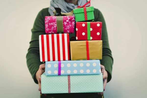 Jonge vrouw met een stapel van geschenken — Stockfoto