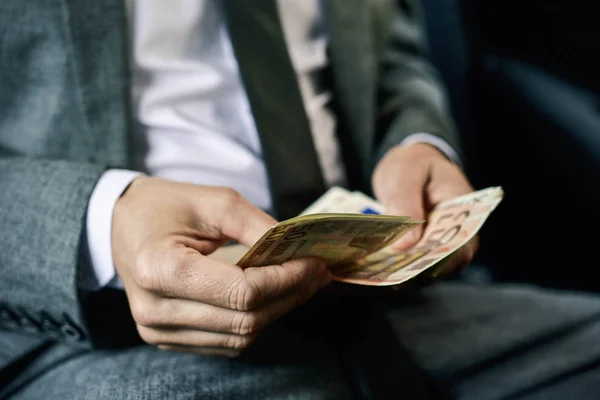 Man counting euro bills in the back of a car — Stock Photo, Image