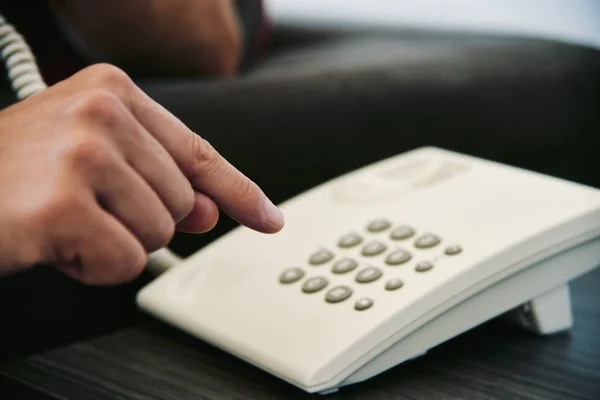 Young man dialing on a landline telephone — Stock Photo, Image