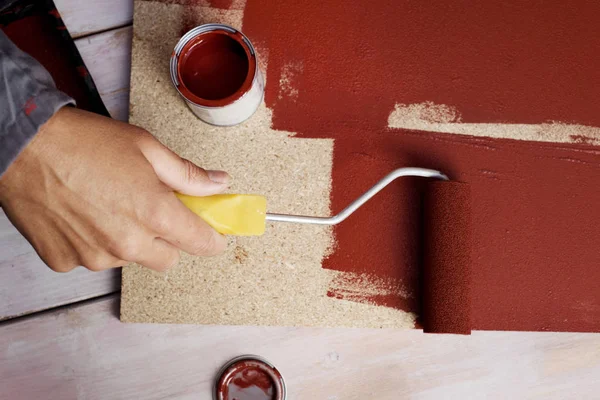 Jovem pintando uma tábua de madeira — Fotografia de Stock