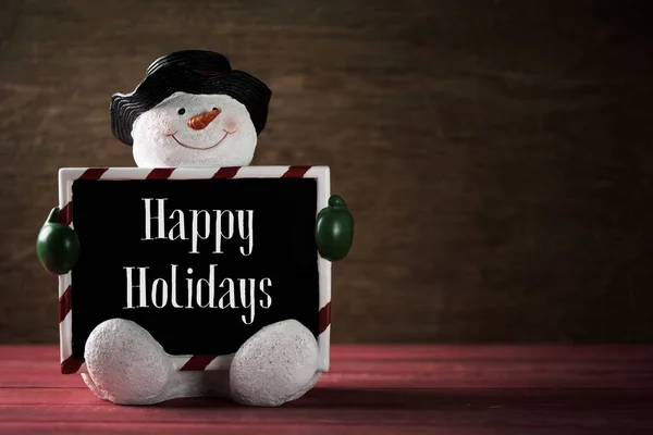 Sneeuwpop en tekst prettige feestdagen — Stockfoto