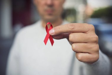 AIDS'e karşı mücadele için kırmızı kurdele ile adam