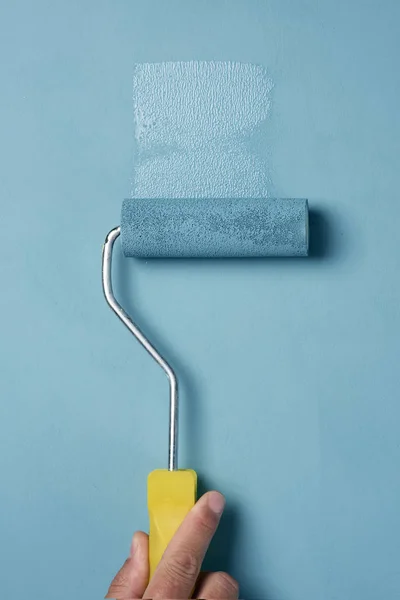 Young man painting with a paint roller — Stock Photo, Image