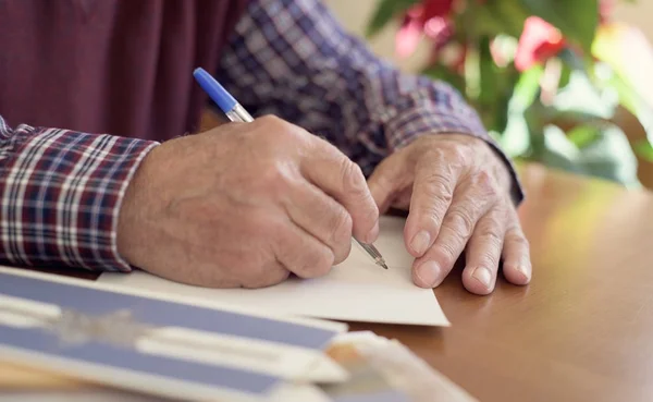 Viejo hombre escribiendo tarjetas de Navidad — Foto de Stock