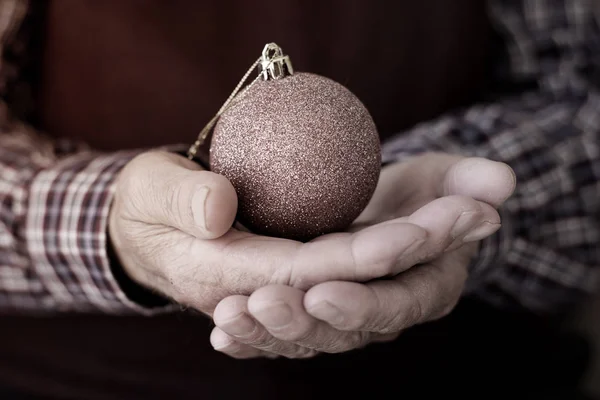 Vieil homme avec une boule de Noël dans ses mains — Photo