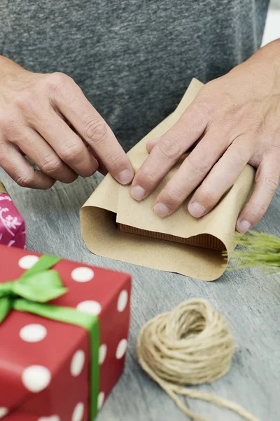 Ung man inslagning gåvor — Stockfoto