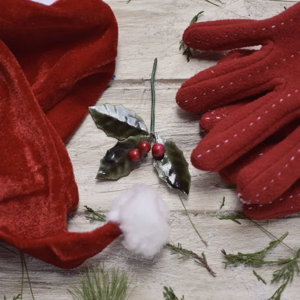 Sombrero de santa, guantes rojos y acebo — Foto de Stock