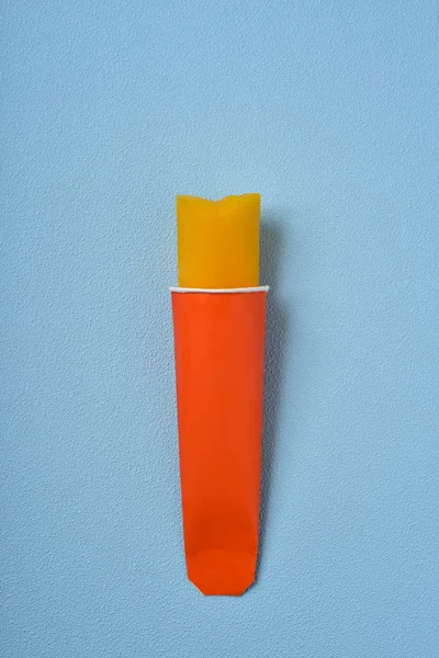 Picolé laranja em um fundo azul — Fotografia de Stock