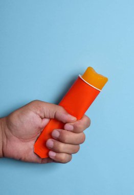 turuncu bir buzlu şeker elinde olan genç adam