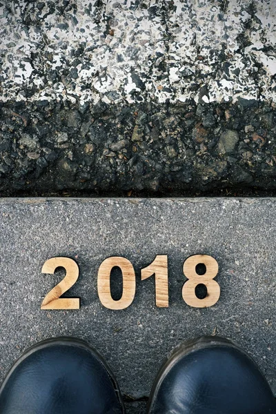 Pies y número 2018, como el nuevo año, sobre asfalto —  Fotos de Stock