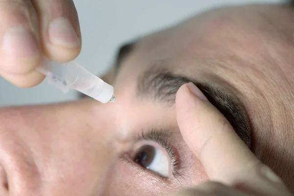 Homem aplicando colírio em seus olhos — Fotografia de Stock