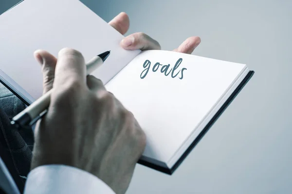 Man about to write a list of goals in a notebook — Stock Photo, Image