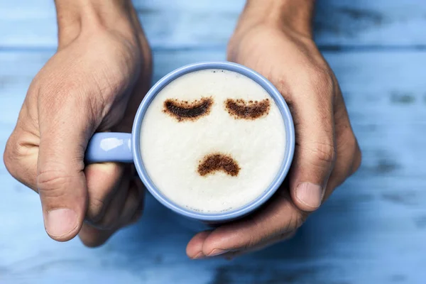 Człowiek z filiżanką cappuccino z smutną twarz — Zdjęcie stockowe
