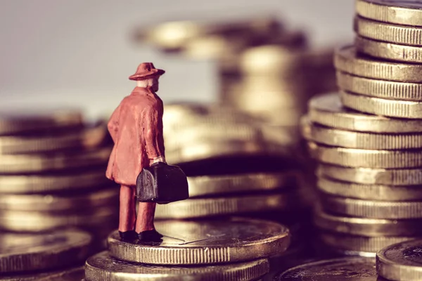 Miniature traveler on a pile of euro coins — Stock Photo, Image