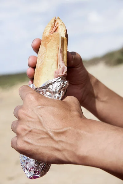 Молодий чоловік їсть бутерброд на відкритому повітрі — стокове фото